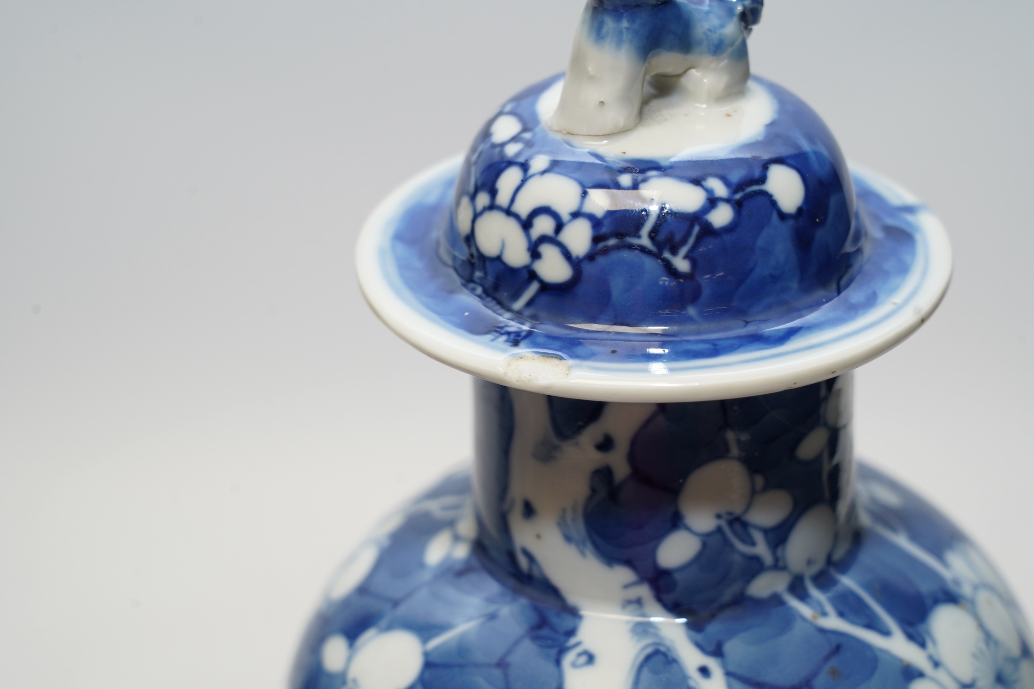 A pair of Chinese blue and white prunus baluster vases and covers, 31cm high. Condition - one vase good, the other pieces poor